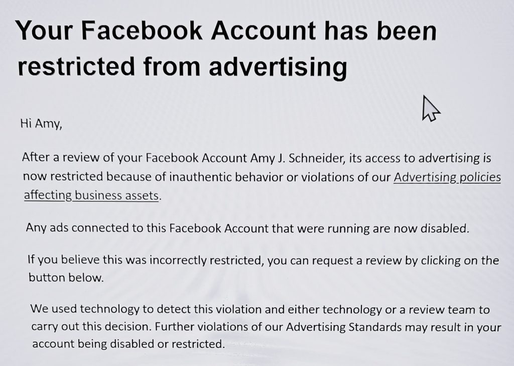 The image contains the following text:
Your Facebook Account has been restricted from advertising
Hi Amy,
After a review of your Facebook Account Amy J. Schneider, its access to advertising is now restricted because of inauthentic behavior or violations of our Advertising policies affecting business assets.
Any ads connected to this Facebook Account that were running are now disabled.
If you believe this was incorrectly restricted, you can request a review by clicking on the button below.
We used technology to detect this violation and either technology or a review team to carry out this decision. Further violations of our Advertising Standards may result in your account being disabled or restricted.