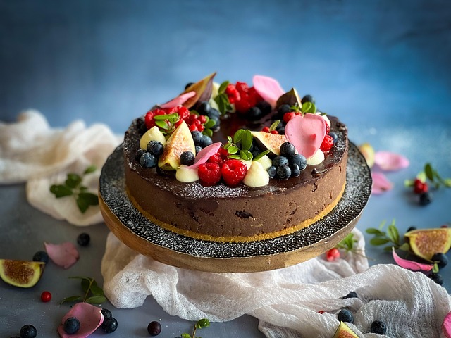 Figs and berries piled on a chocolate torte artfully arranged high on a cake plate.